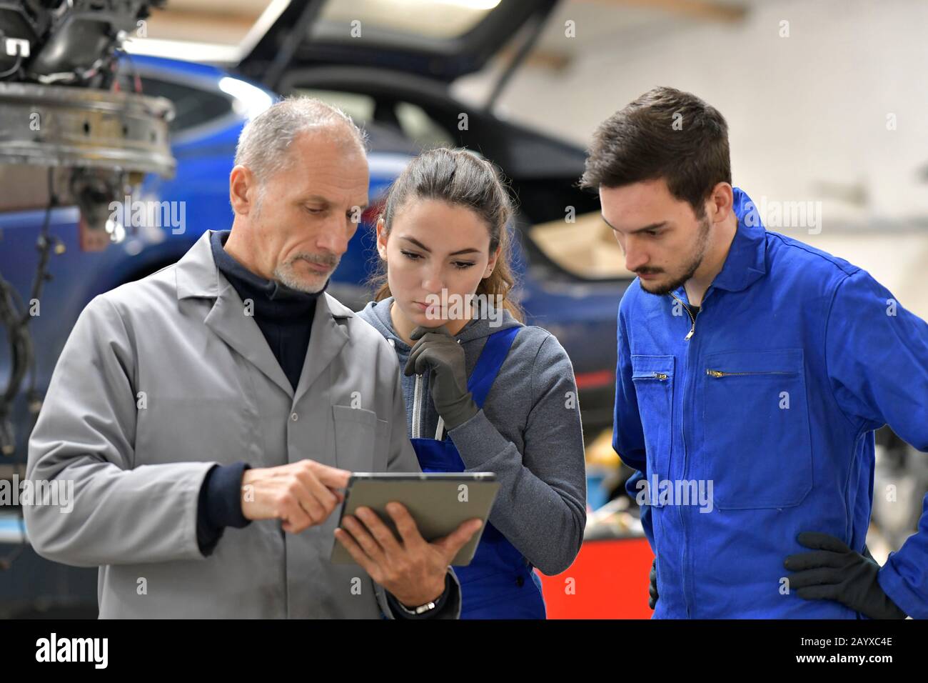 Apprentice with instructor using tablet in workshop Stock Photo
