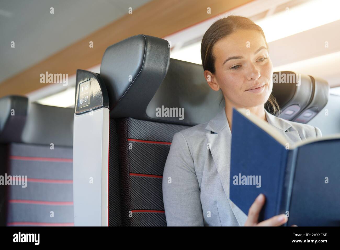 Relaxed businesswoman reading on a train Stock Photo