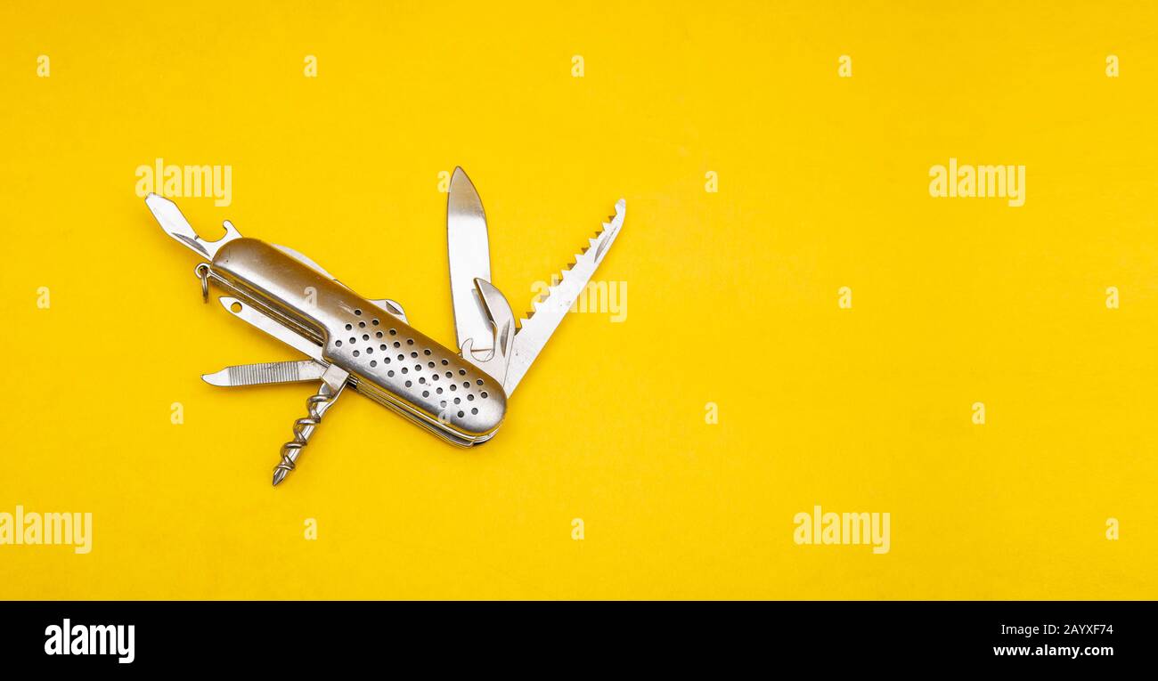 Close up photo of swiss army knife on yellow background with copy space Stock Photo