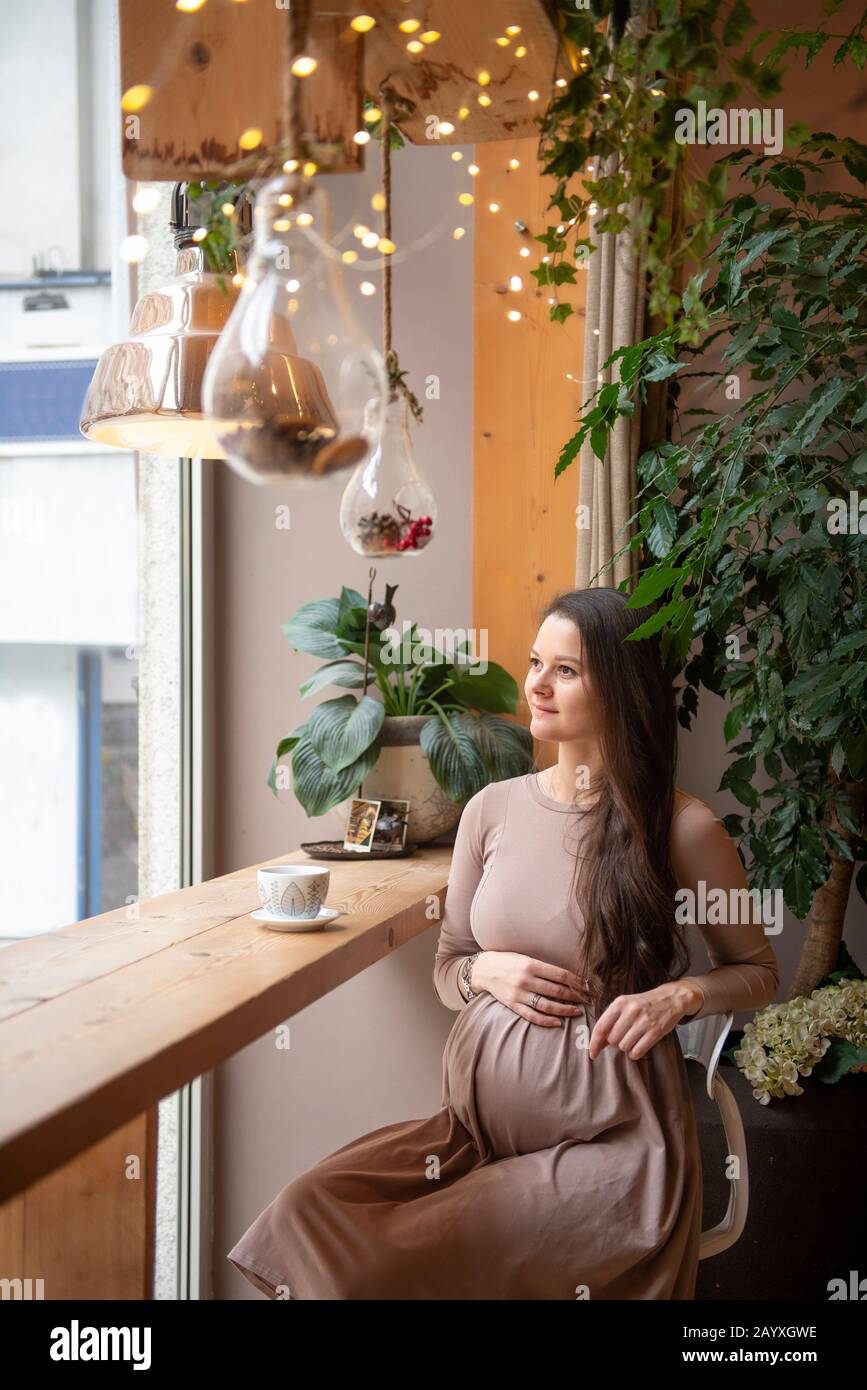 Pregnant woman sitting with cup of tea inside cafe Stock Photo - Alamy
