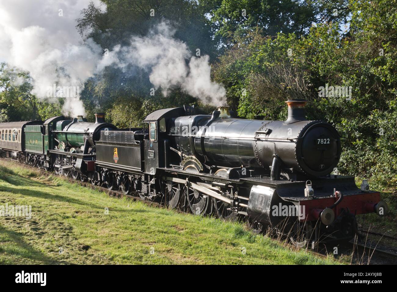 A double header train comprising of 6960 Raveningham Hall and 7822 Foxcote Manor pulling a rain toward Minehead on the West Somerset Railway. Stock Photo