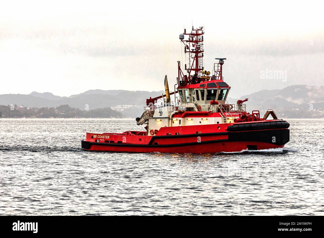 Tug boat BB Coaster at Byfjorden, outside port of Bergen, Norway. A rainy and foggy winter day Stock Photo