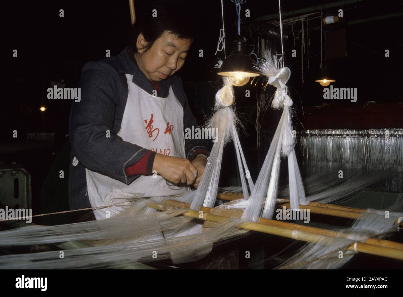 A woman is working in a silk factory in Wuhan in China. Stock Photo