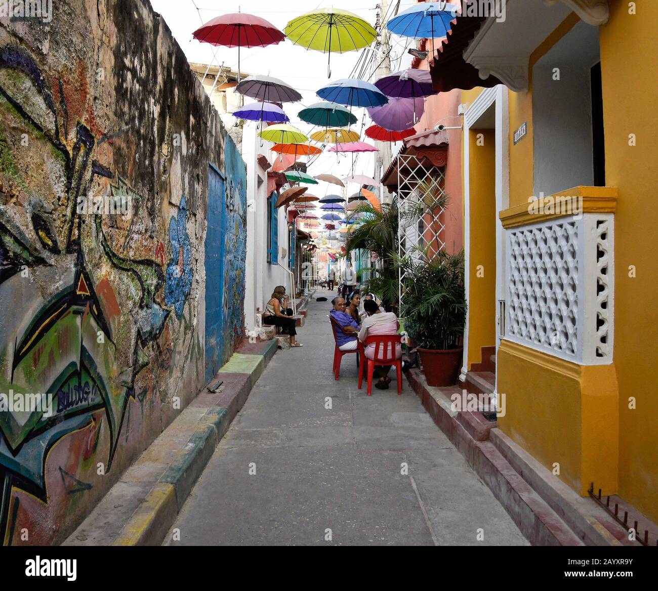 Street art and overhead umbrellas provide color and shade on Callejon