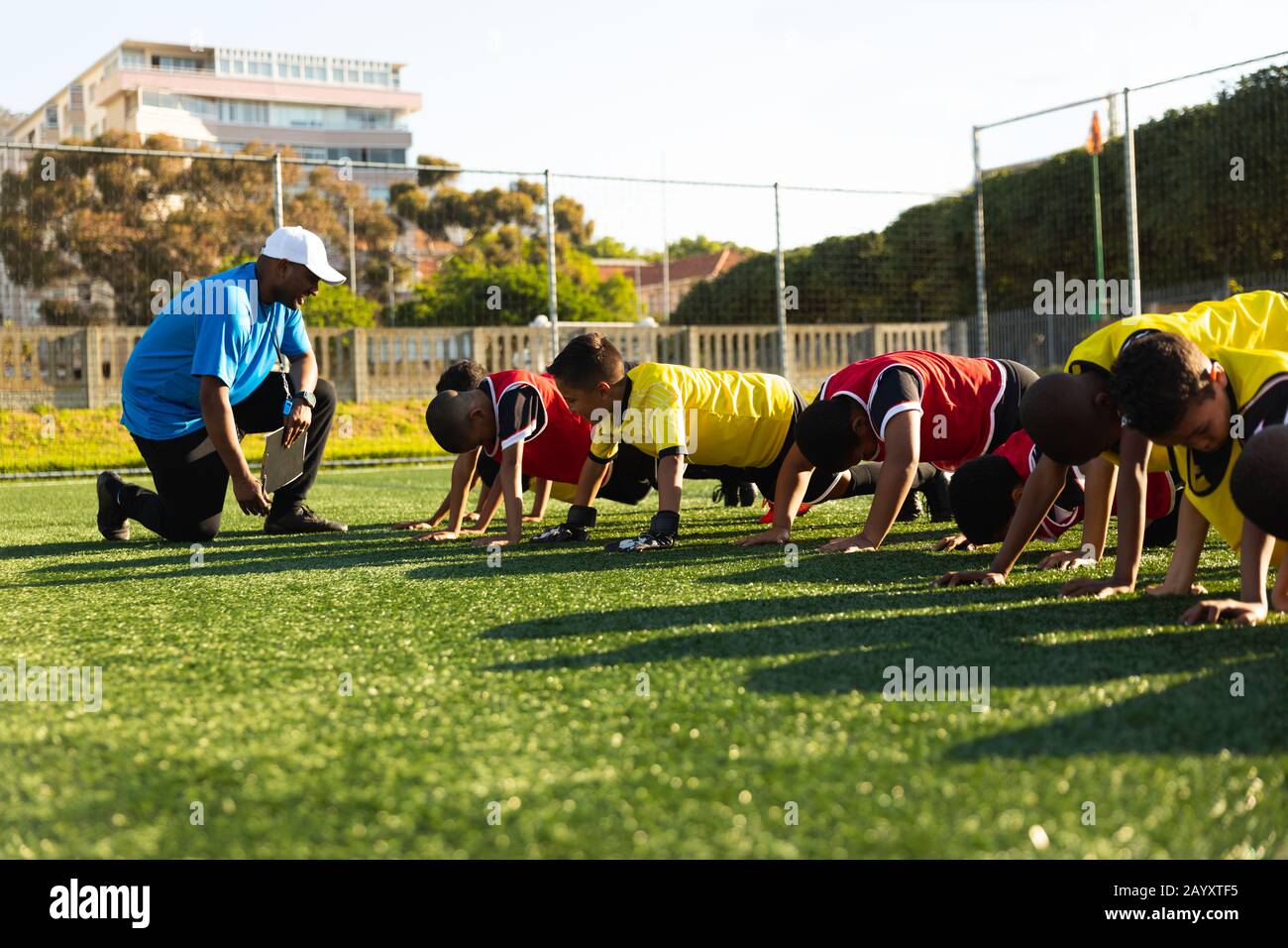 Soccer players doing push ups while coach is looking Stock Photo Alamy