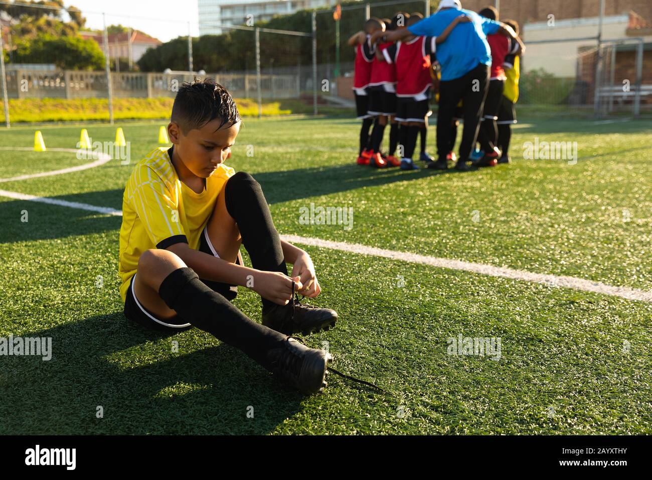 Front view soccer player putting on his shoes Stock Photo