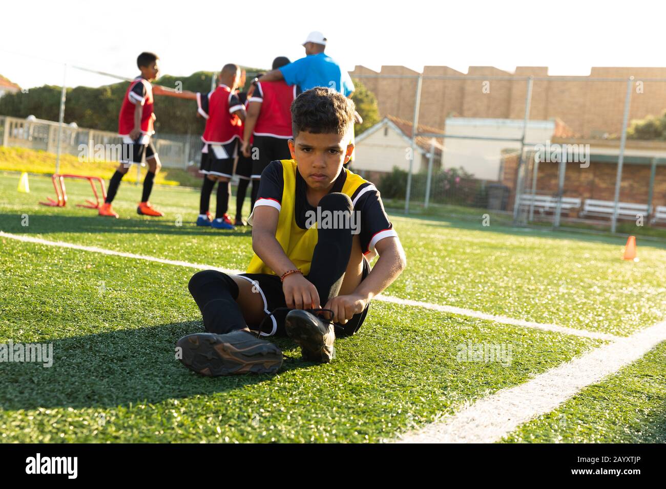 Front view soccer player putting on his shoes Stock Photo