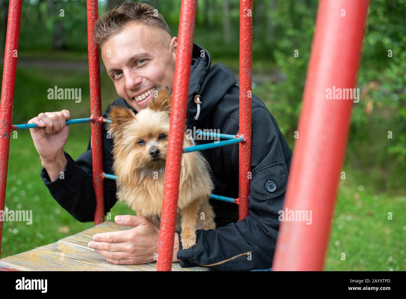 A man with a little dog on a swing. Stock Photo