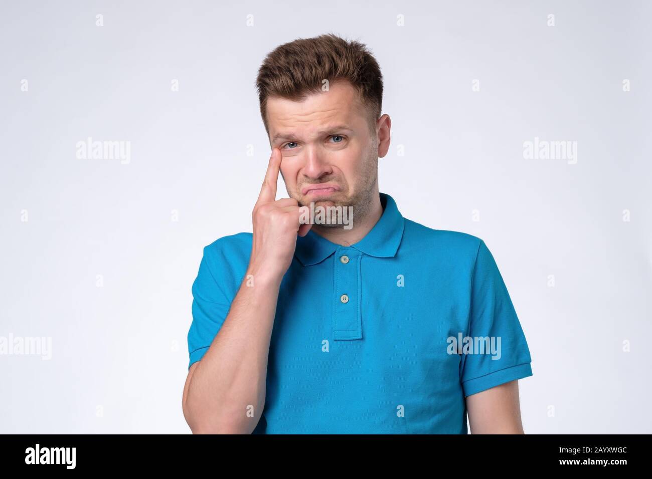 Young caucasian man with sad expression is about to cry. Studio shot ...