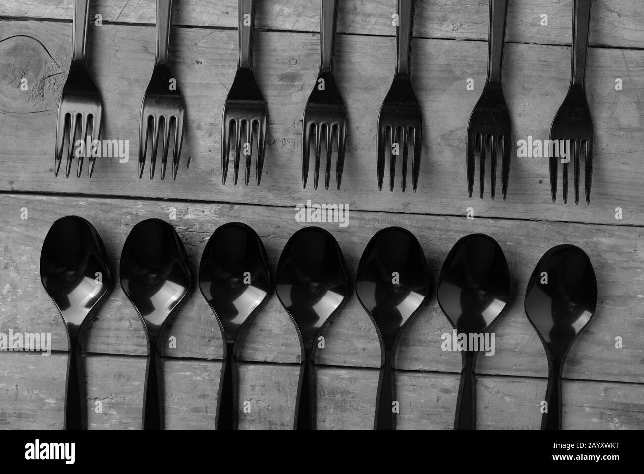 top view of plastic spoons and forks on wooden background Stock Photo