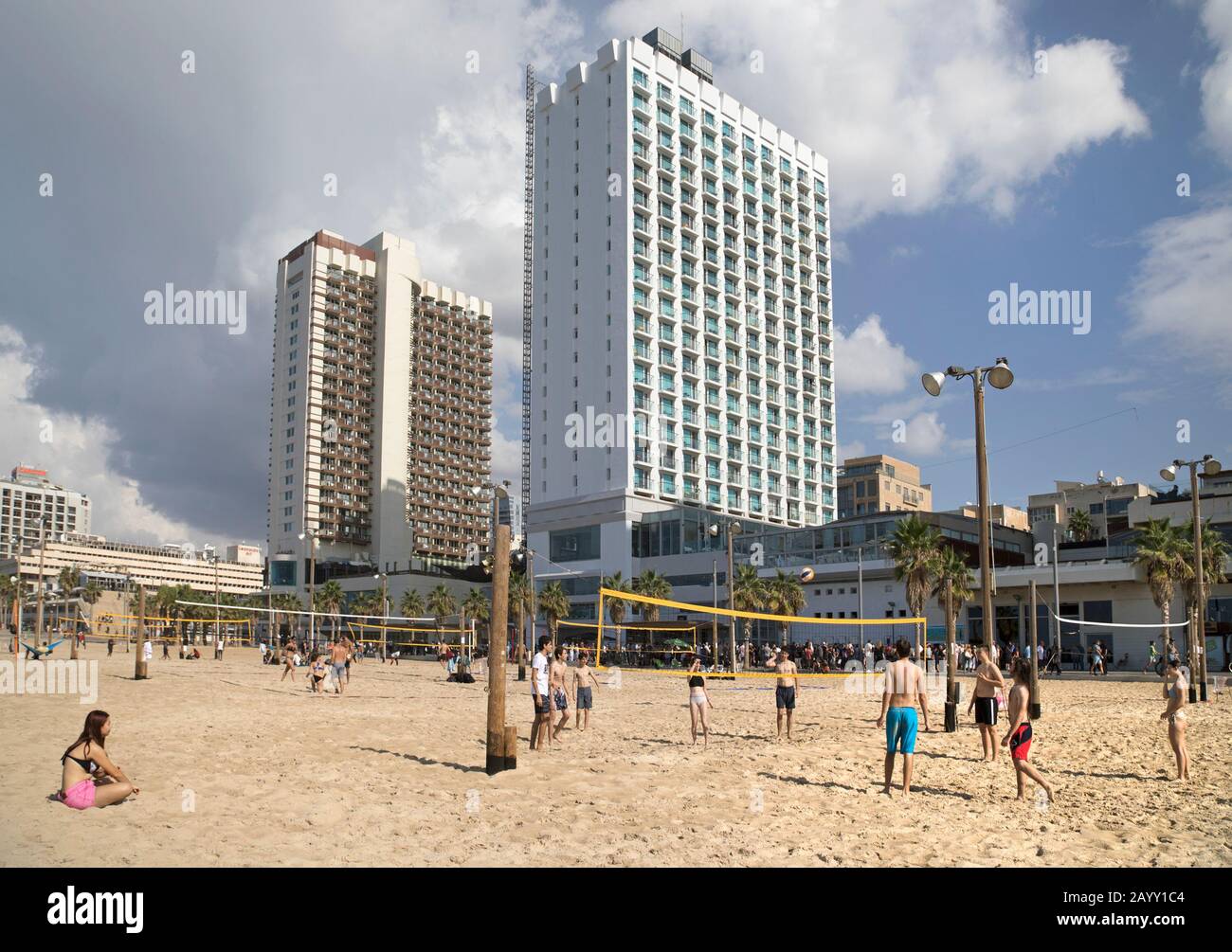 Volleyball players on the sand along the promenade of Gordon Beach in Tel Aviv, beside the hotel zone with Crowne Plaza and Herod's hotels. Israel. Stock Photo