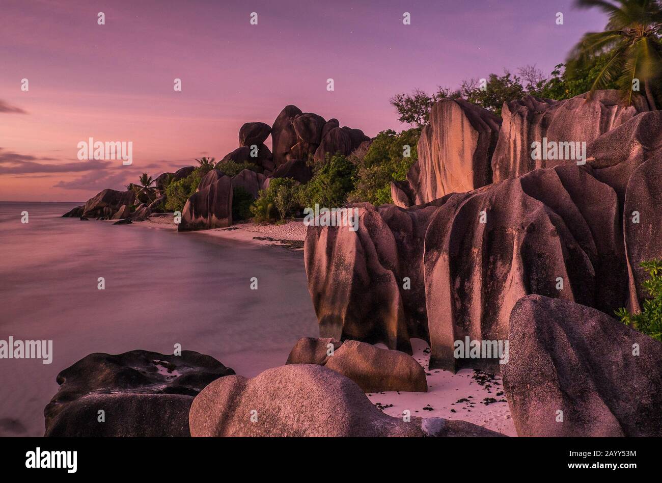 Twilight on rocks and ocean at Source D Argent beach on La Digue, Seychelles Stock Photo