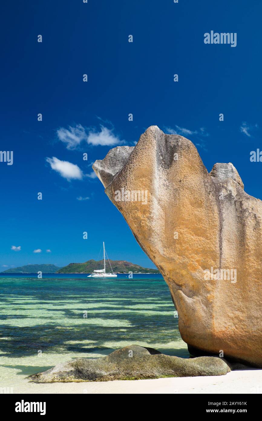 Freestanding glacis rockformation and sailboat on Curieuse Island, Seychelles. Praslin Island in the background Stock Photo