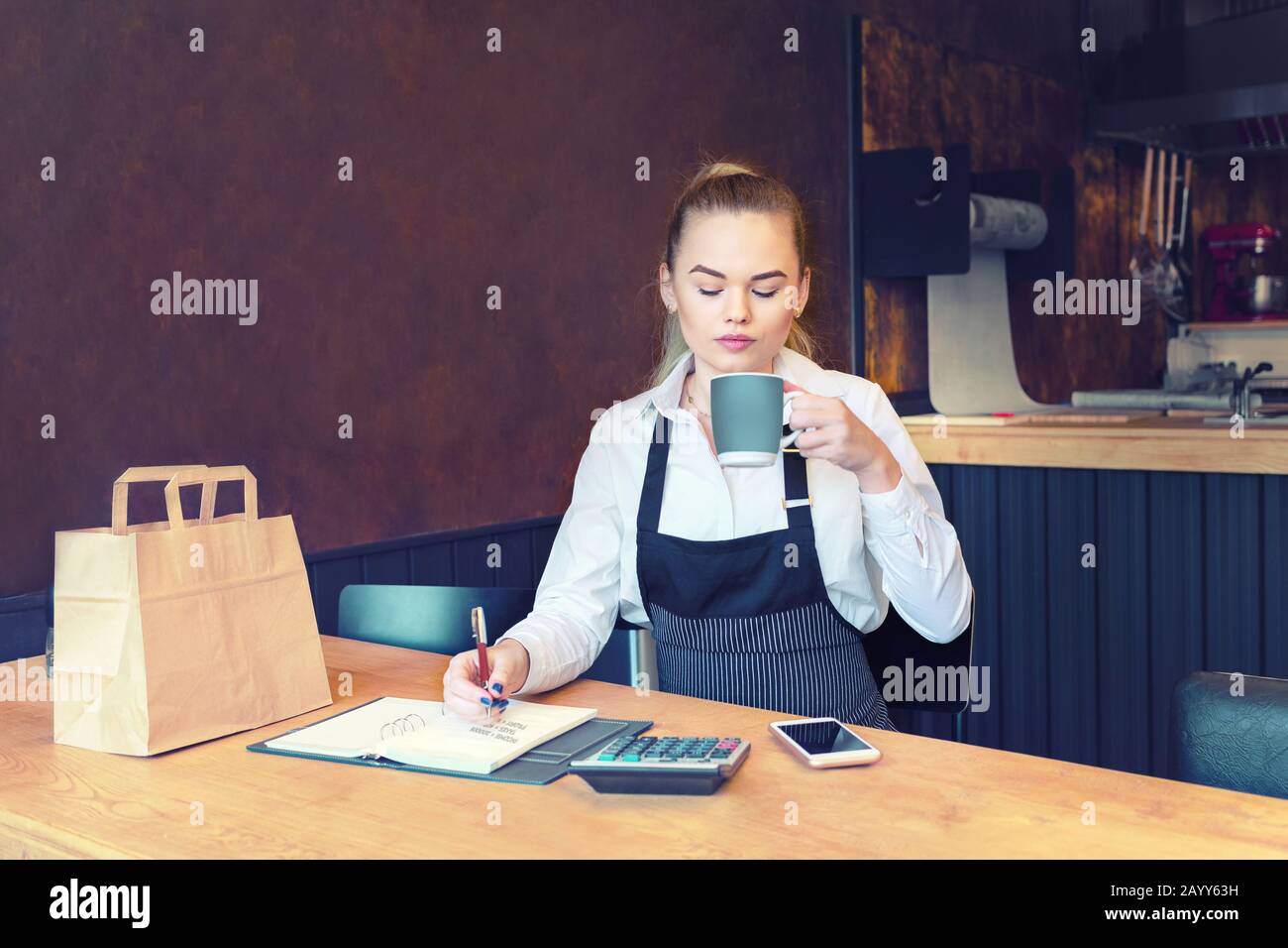 Young new small business owner calculating restaurant bills expenses and taxes Stock Photo
