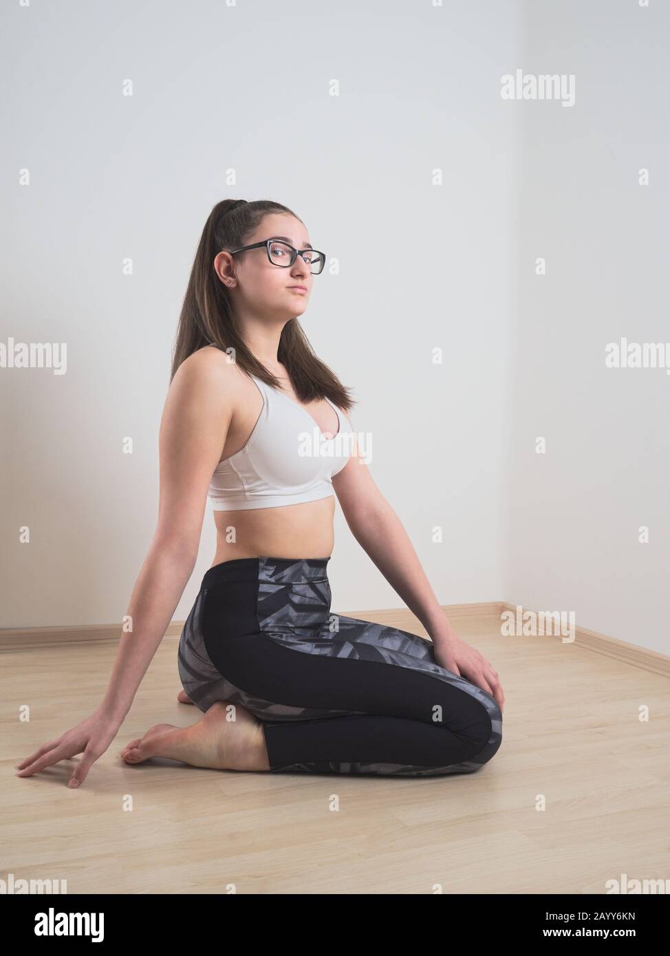 Full length colour studio portrait female wearing pink shirt and black  leggings on grey neutral background, hand placed on head Stock Photo - Alamy