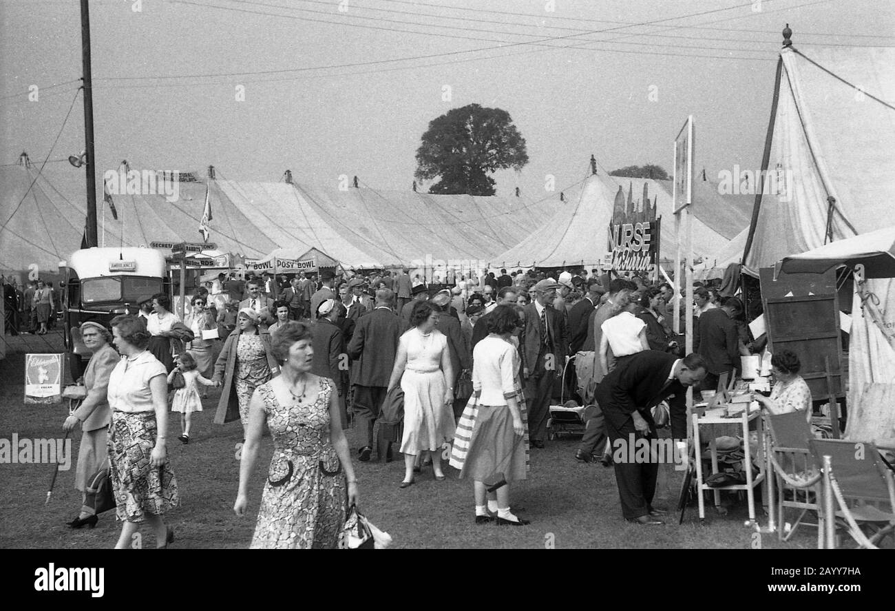 1950s, historical, visitors to The Thame show, Oxfordshire, England, showing the fashions worn by people of this era wandering around the tented village. Stock Photo