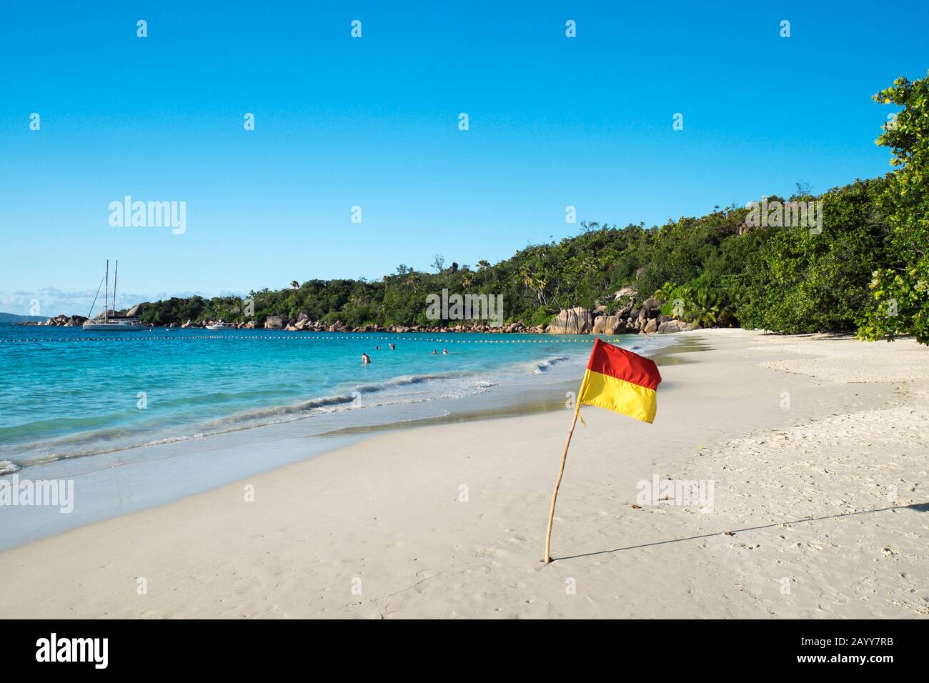 Flag on Anse Lazio, one of Praslin Islands most famous beaches, Seychelles Stock Photo