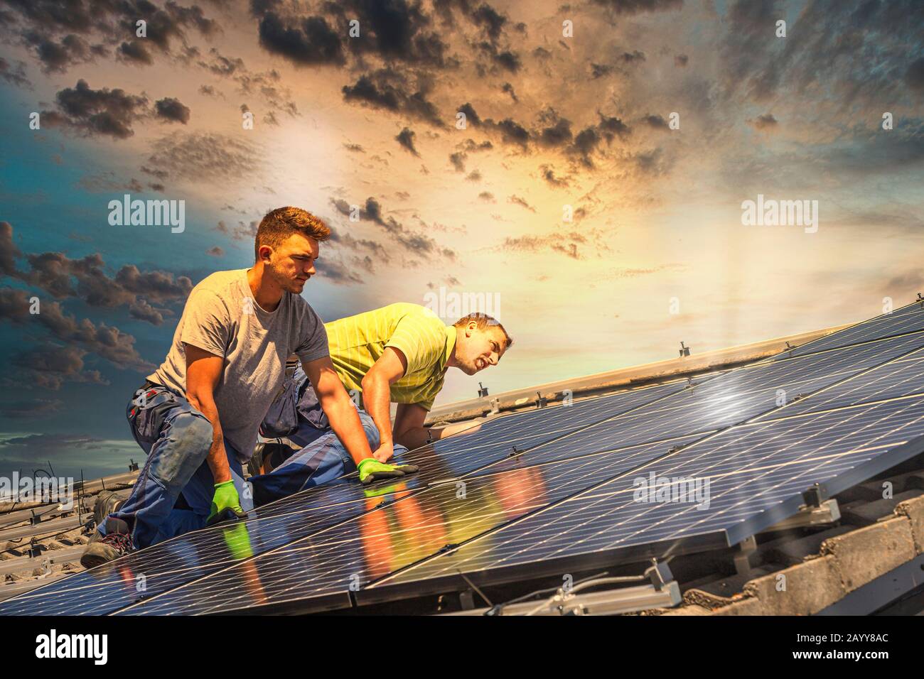 Portrait of workers installing photovoltaic panels on the roof Stock Photo