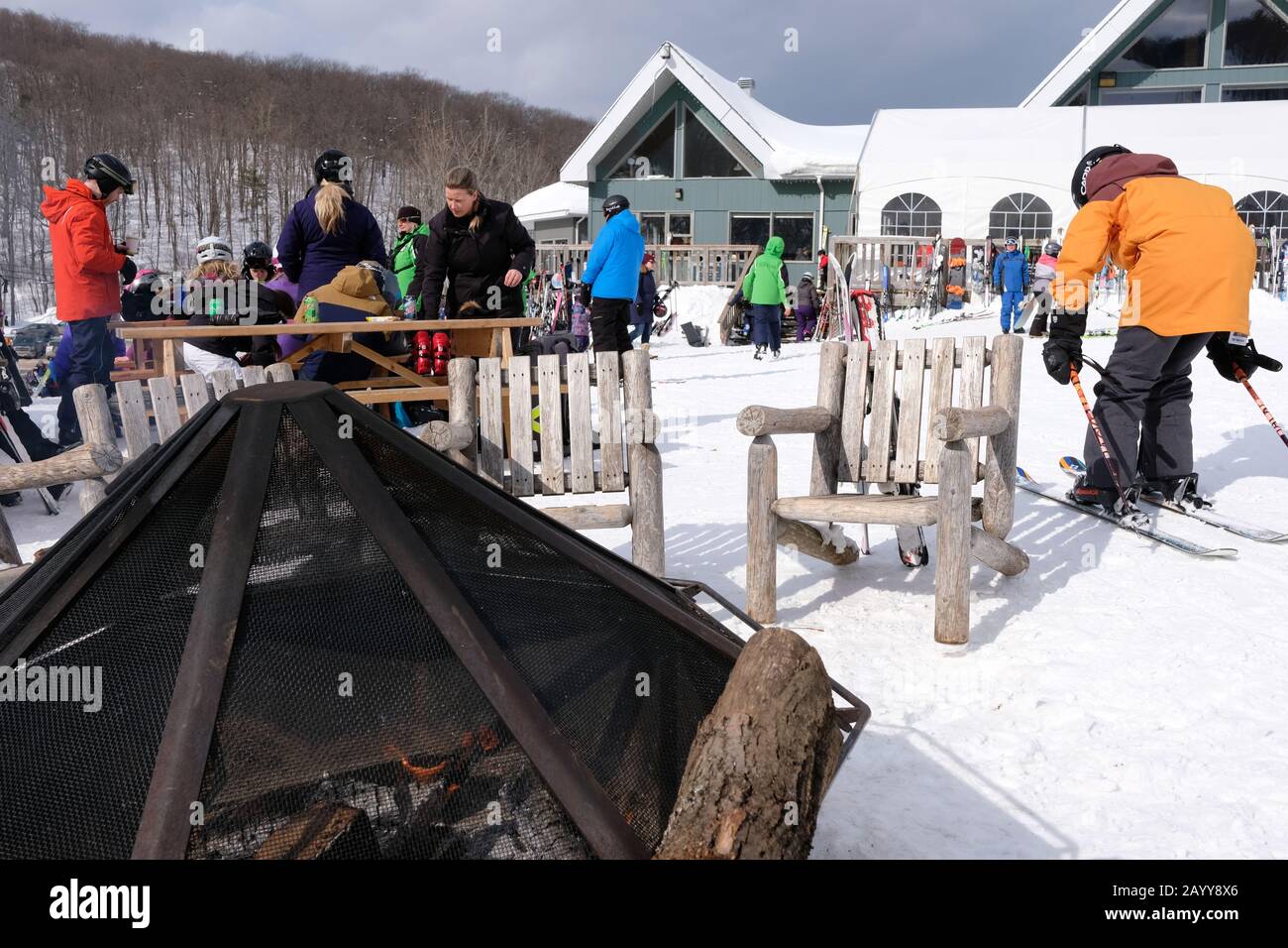 Outdoor fire pit, chalet and skier relaxing at Camp Fortune, Chelsea, Quebec, Canada. Stock Photo