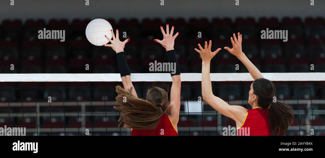 Volleyball game sport with group of girls indoor. Hands and ball over the net Stock Photo Alamy