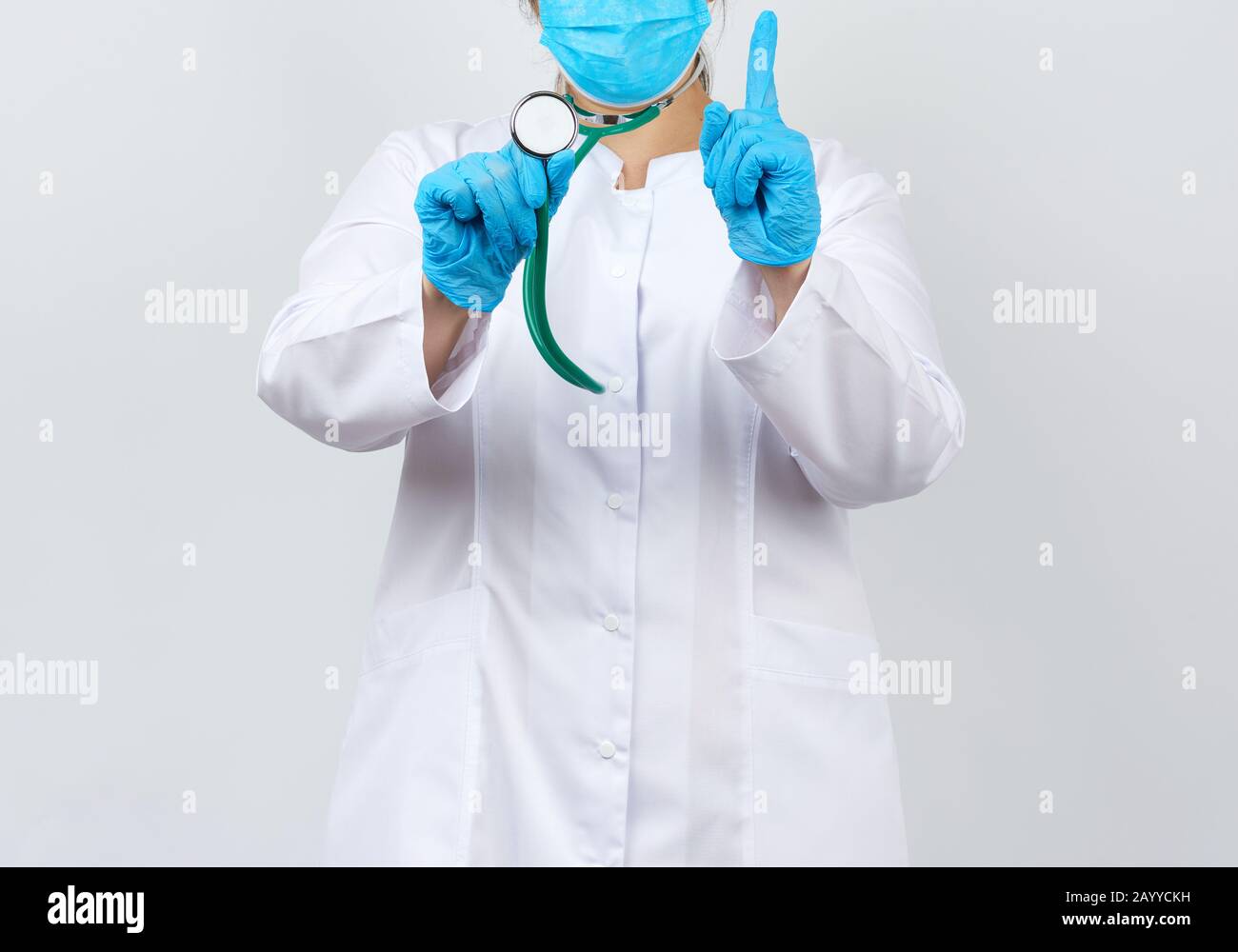 medic woman in a white coat and mask, wearing blue medical latex gloves ...