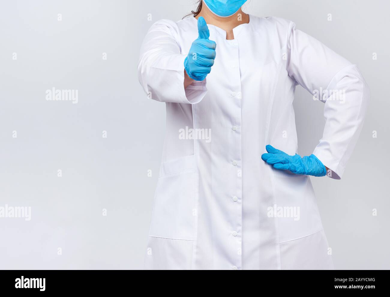 medic woman in white coat and mask, wearing blue medical latex gloves ...