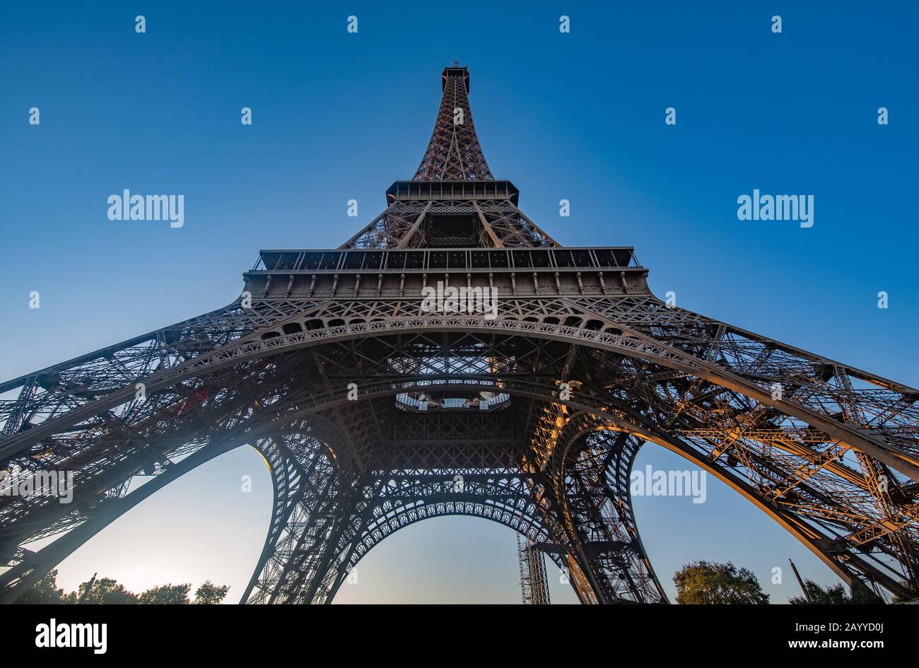 Eiffel Tower seen from below with a blue sky in the background Stock Photo