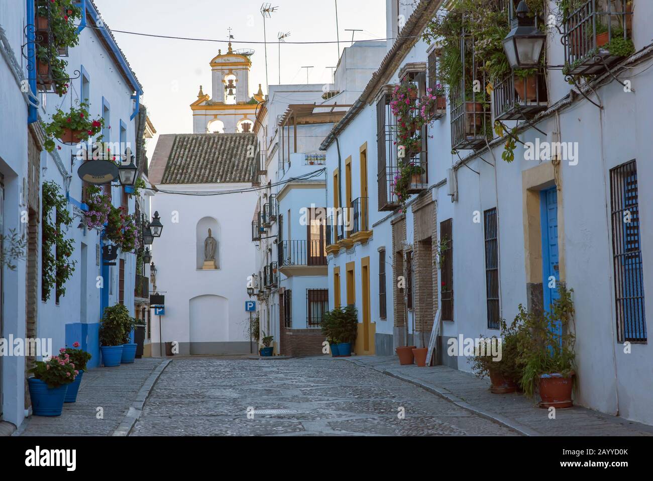 Cordoba city street with colorful pots and a church in the background Stock Photo