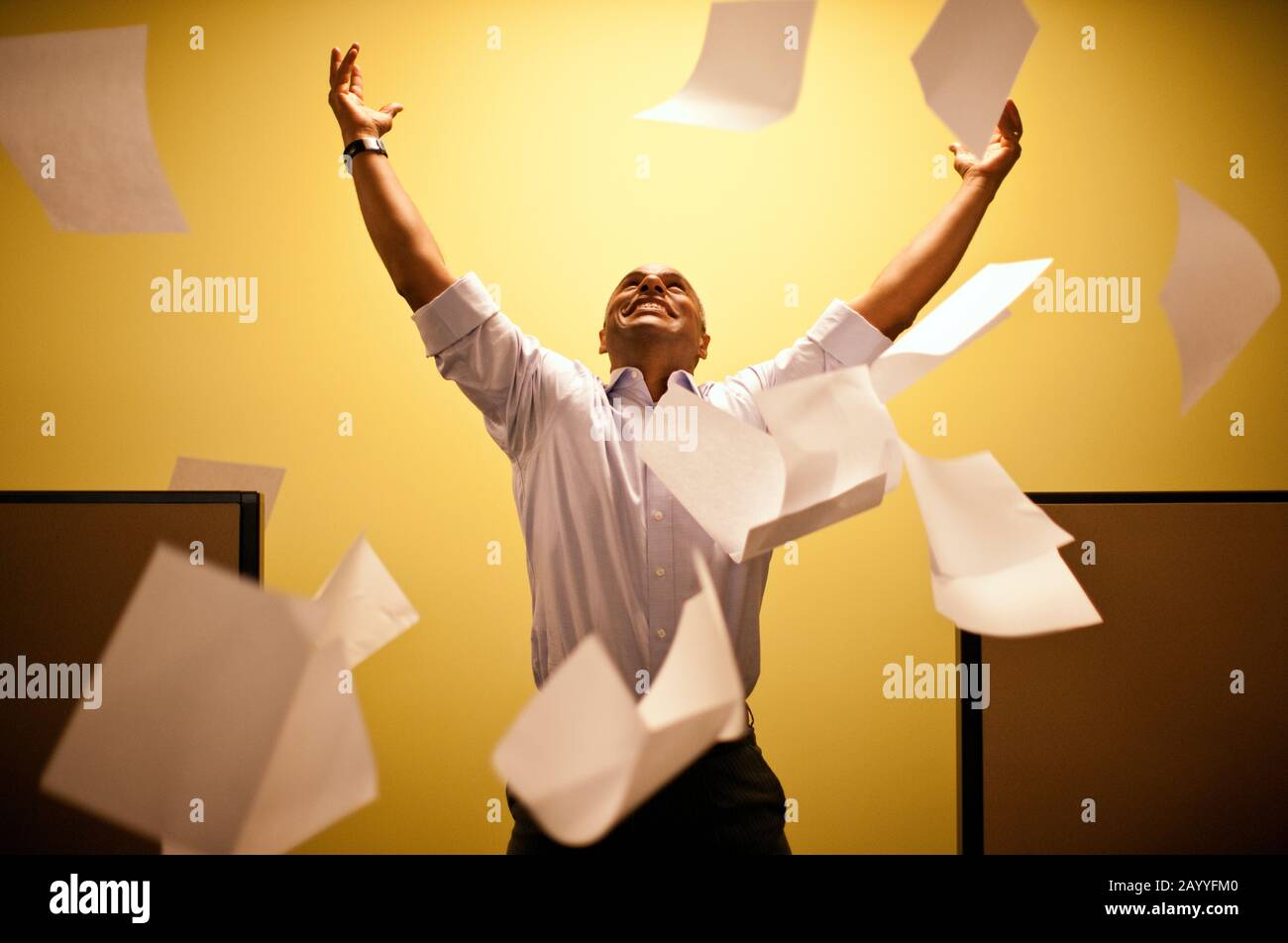Man shouts throwing paper into the air arms raised. Stock Photo
