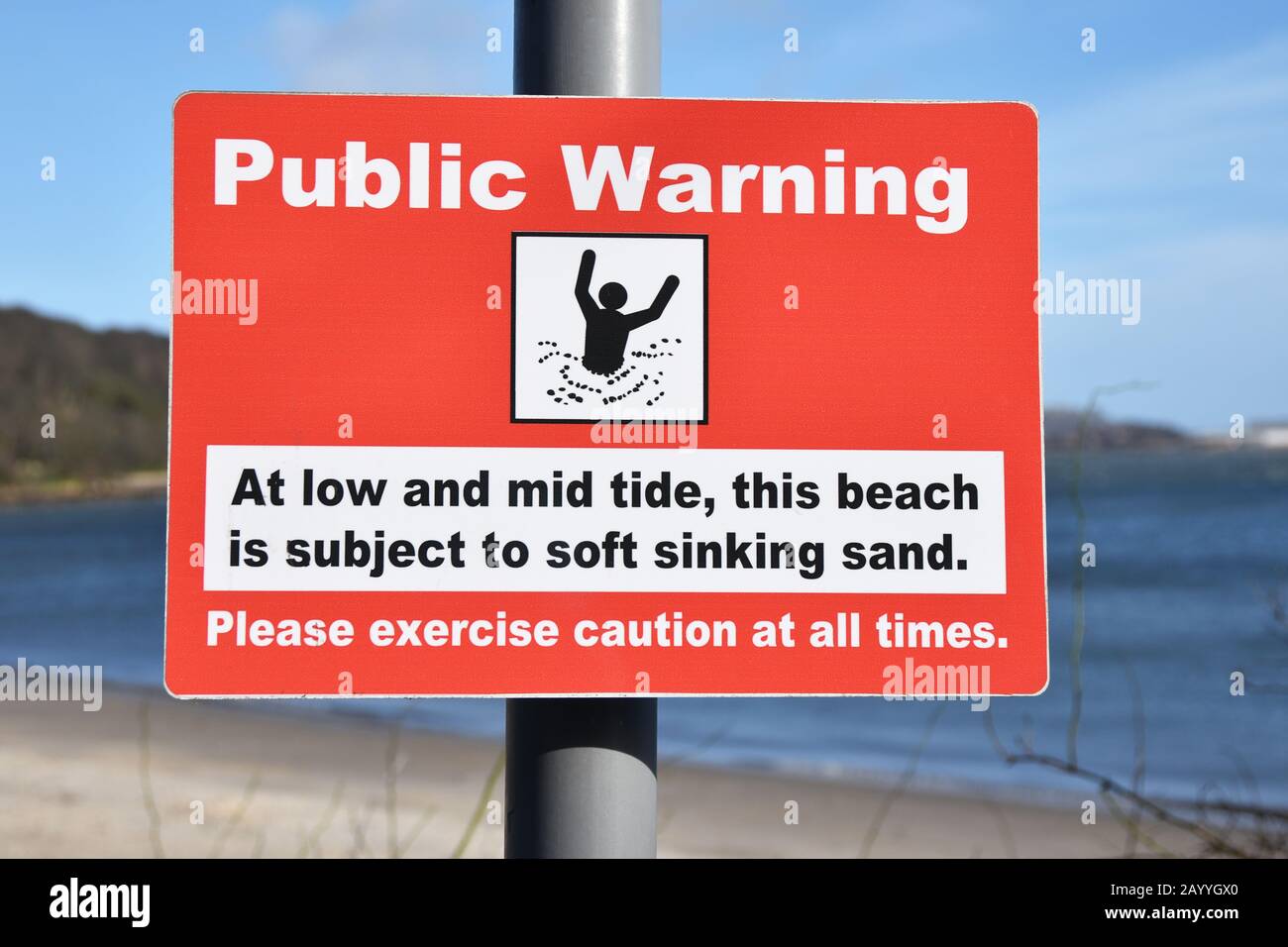 Rectangular public warning sign on beach for soft sinking sand at low and mid tide Stock Photo