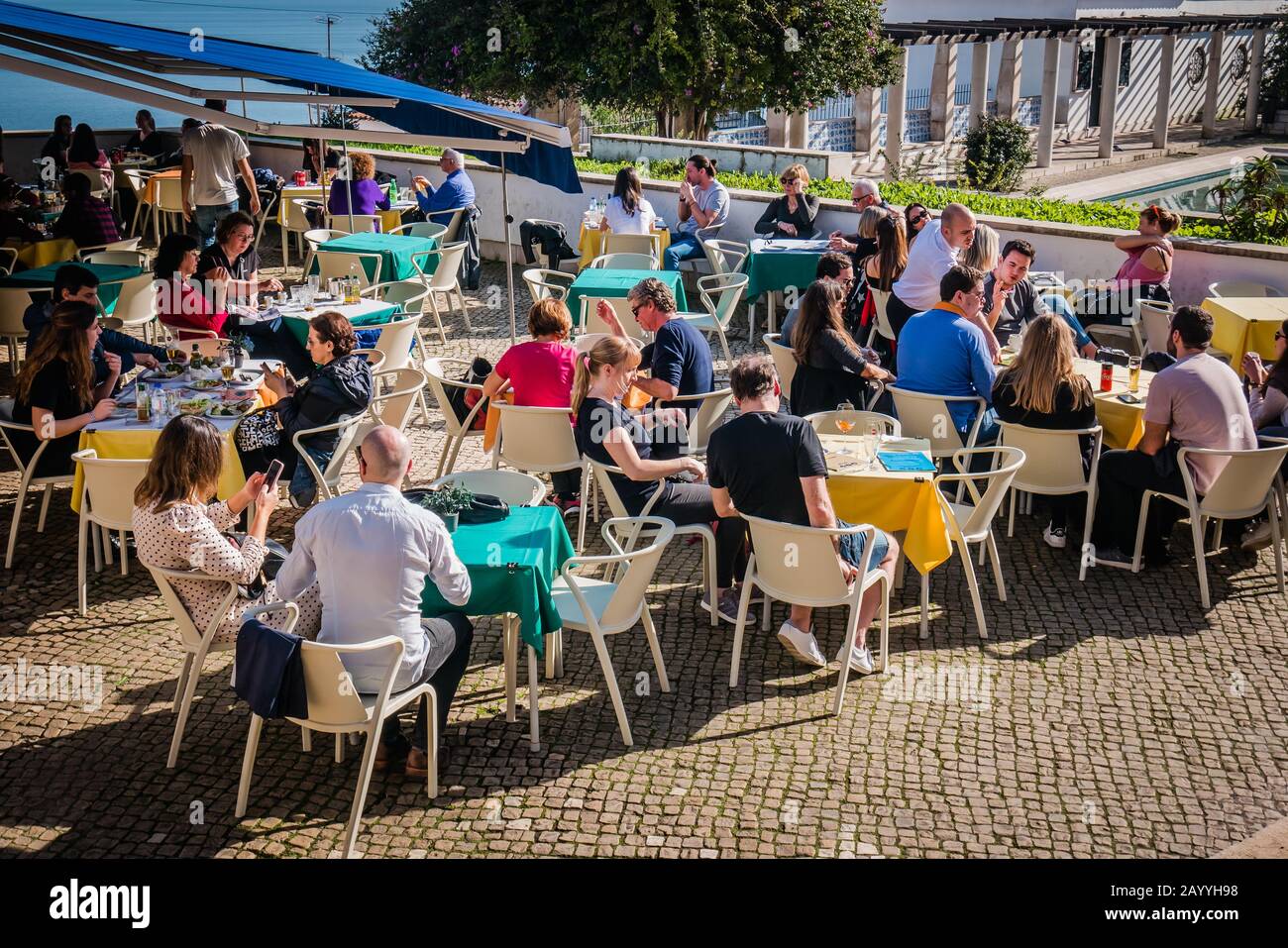 people enjoying the sunny outdoor paitio in lisbon portugal Stock Photo