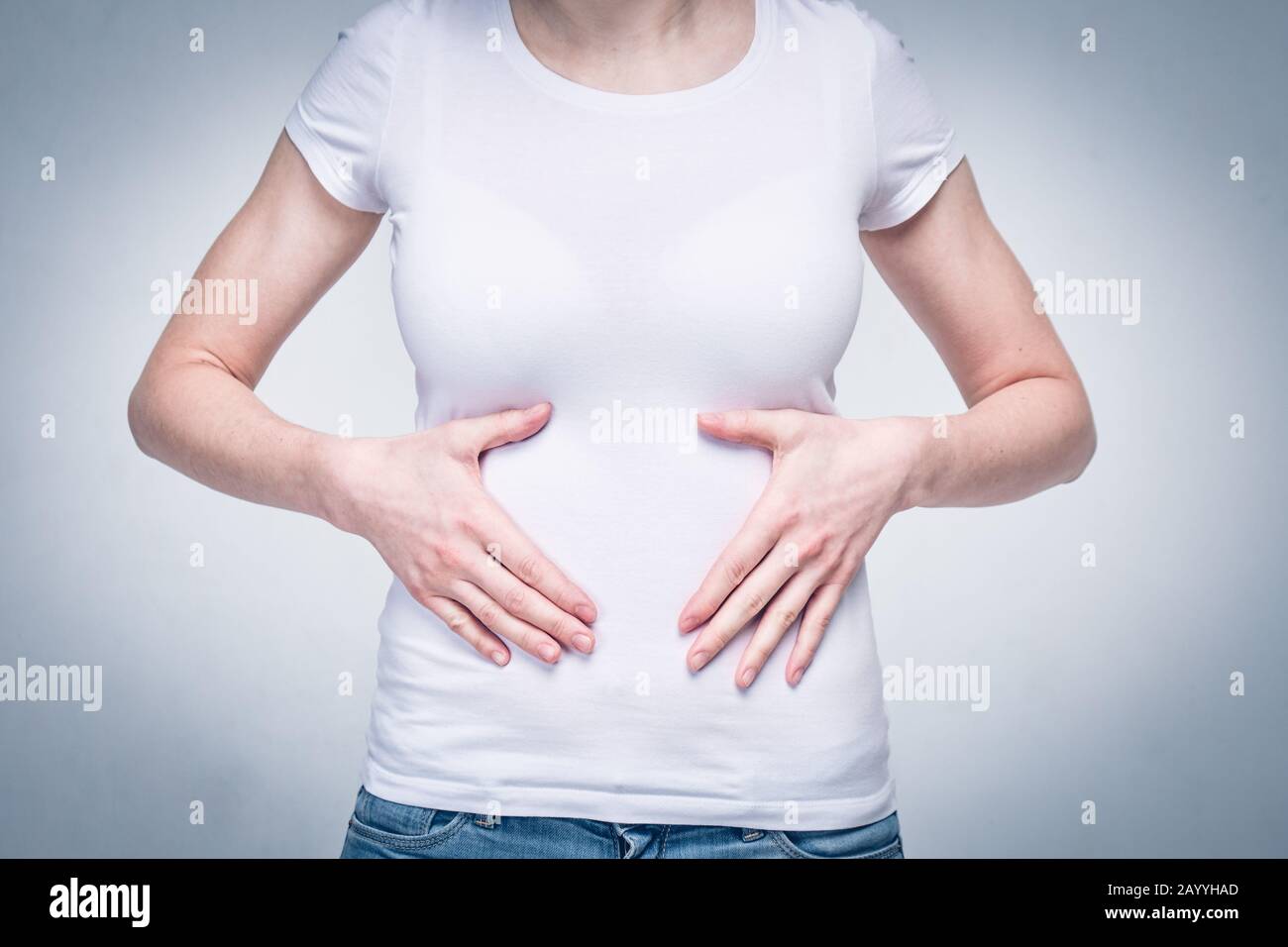 Portrait of a girl in a white T-shirt suffering from pain in the stomach  and stomach due to poor food and malnutrition. Toned. Close up Stock Photo  - Alamy