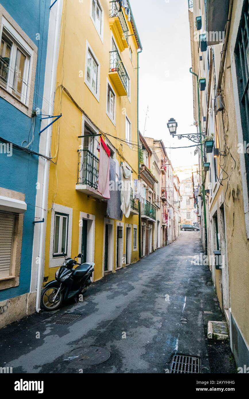 colorful buildings facade houses and an empty narrow pathway in alfama ...