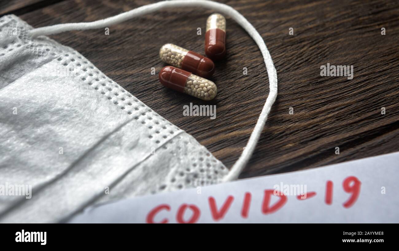 Coronavirus concept. Protective medical mask and pill capsules for treatment of COVID-19 coronavirus. Novel corona virus outbreak. Epidemic from Wuhan Stock Photo