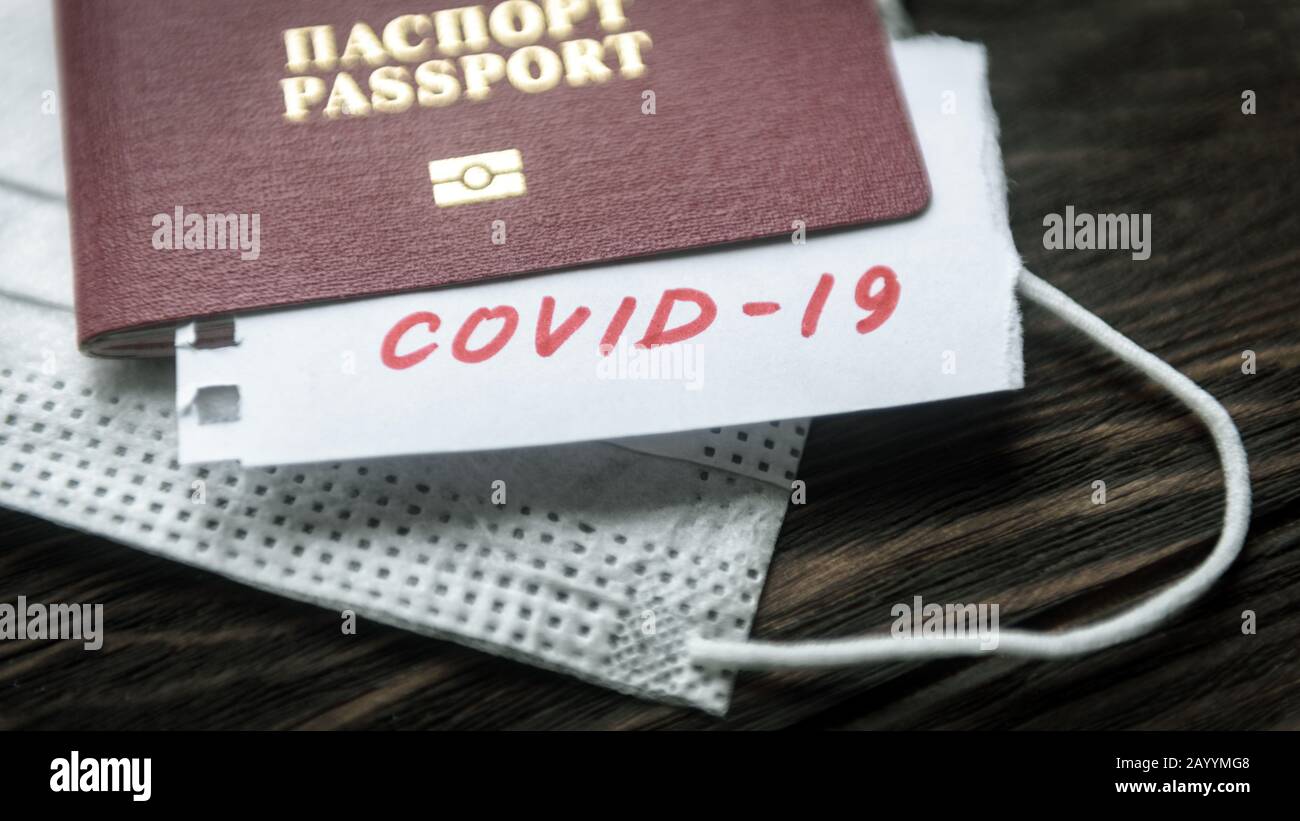Coronavirus and travel concept. Note COVID-19 coronavirus, passport and mask. Corona virus outbreak, epidemic in Wuhan, China. Border control and quar Stock Photo