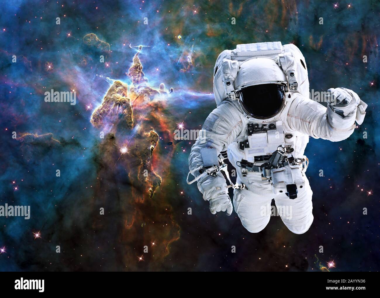 Single astronaut near Mystic Mountain of Carina Nebula. Deep space look. Science fiction wallpaper. Elements of this image were furnished by NASA. Stock Photo