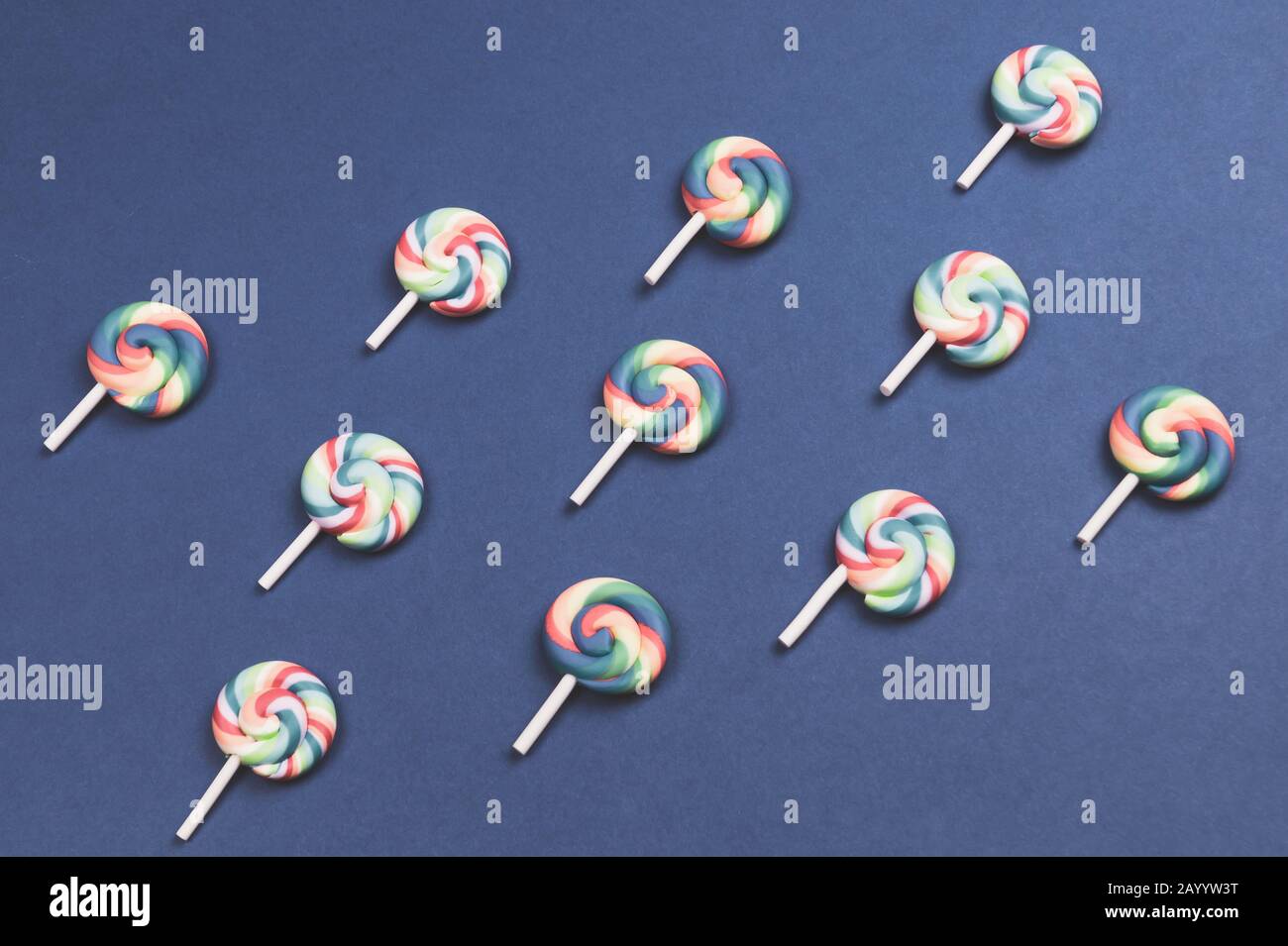 Lollipops are arranged symmetrically on a colored background. colorful candies. pattern of sweets Stock Photo