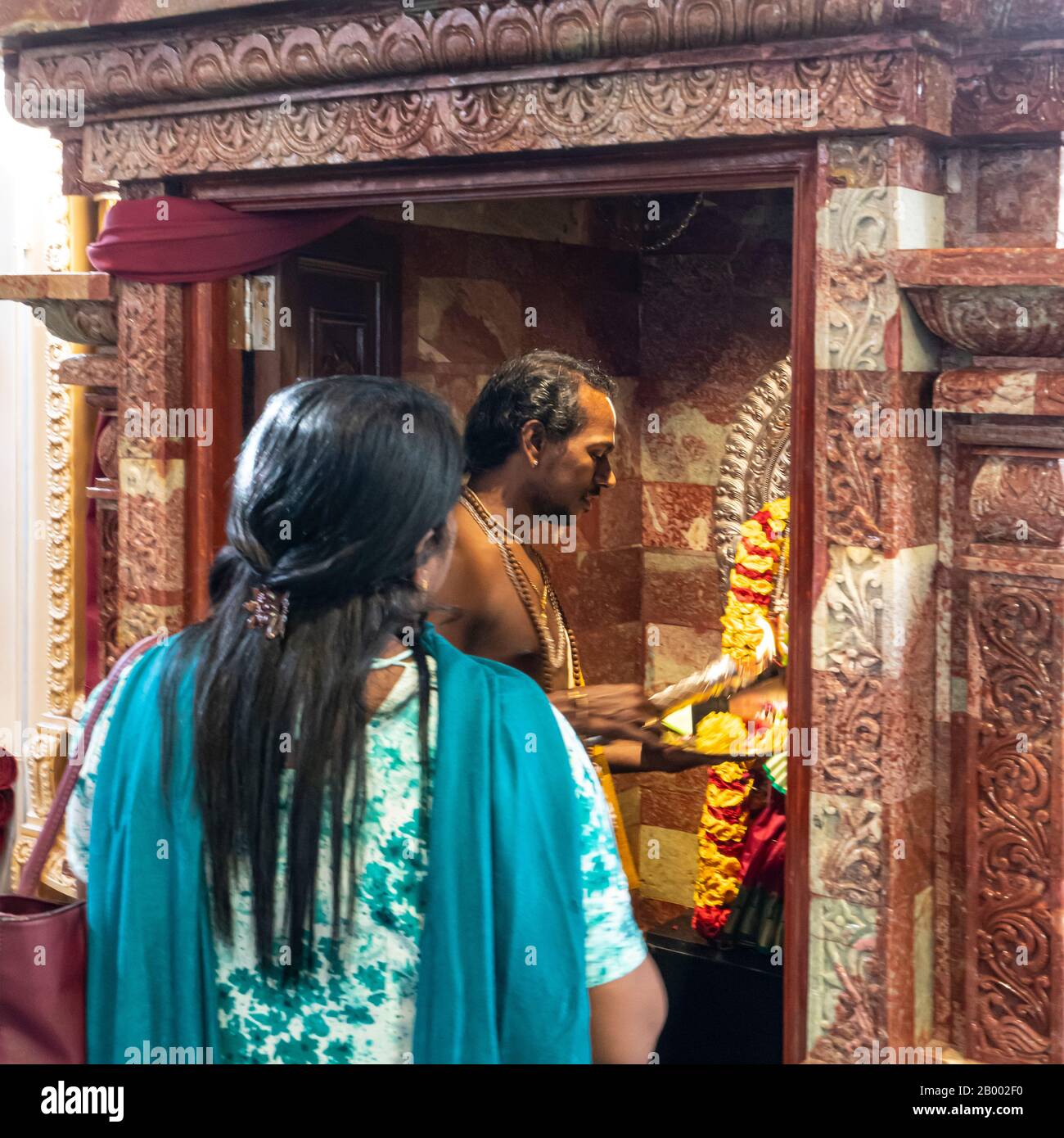 Singapore.  January 2020. a woman prays in front of the altar in a Hindu temple Stock Photo