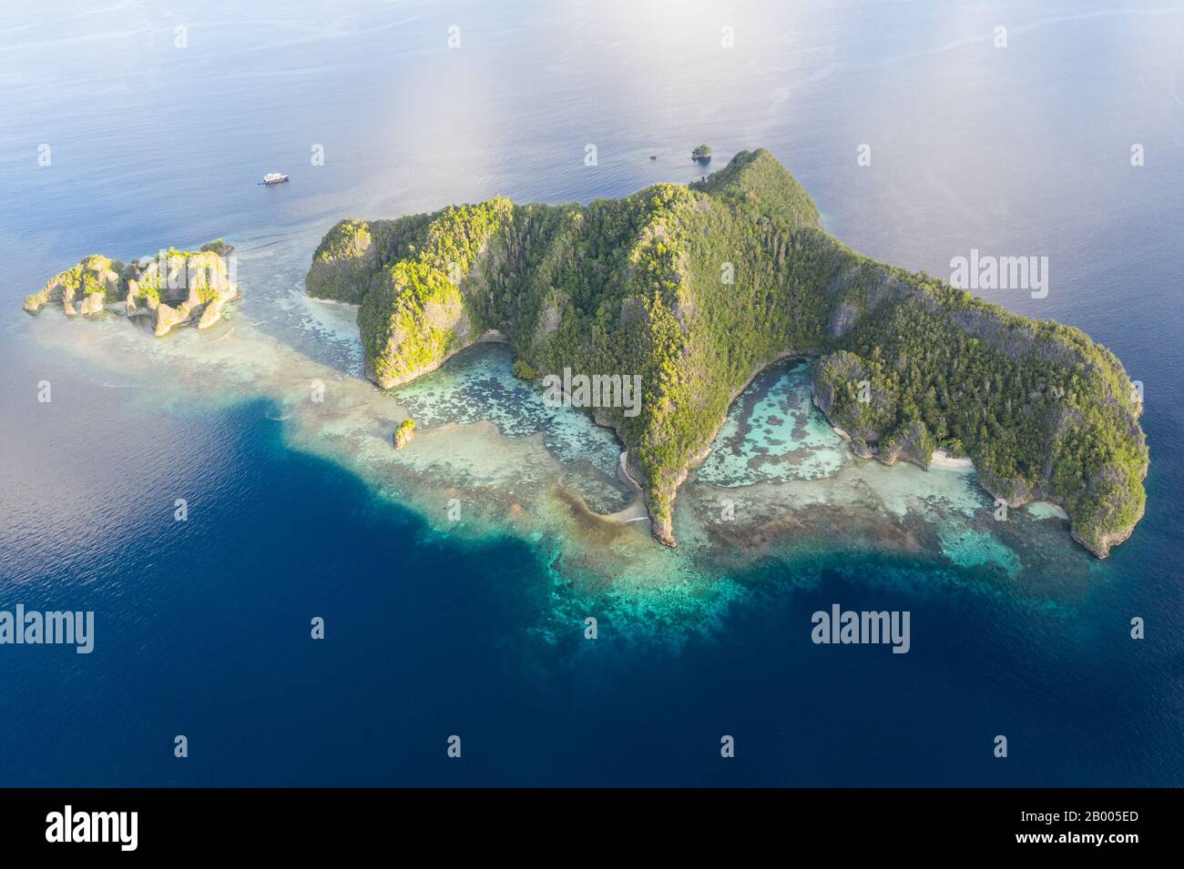 Rugged limestone islands rise from the serene seascape in Raja Ampat ...
