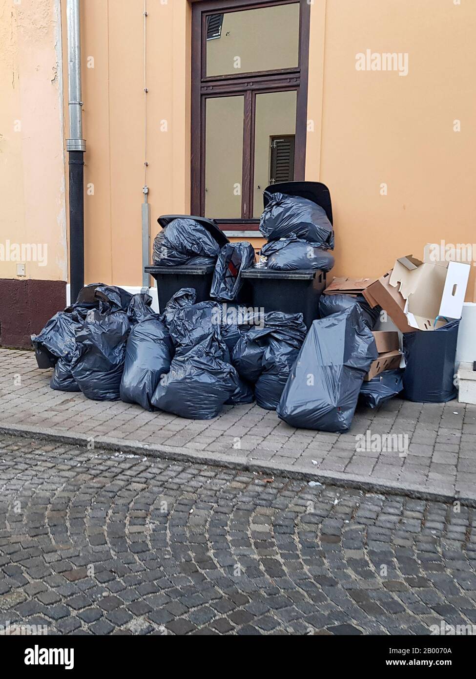 https://c8.alamy.com/comp/2B0070A/a-pile-of-sorted-garbage-on-the-street-there-are-black-bags-bins-and-cardboard-in-the-trash-prepared-for-garbage-collection-2B0070A.jpg