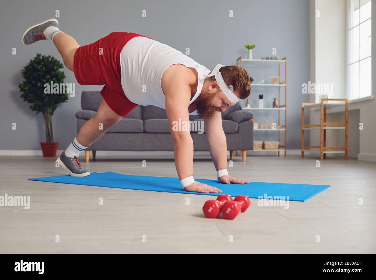 Funny yoga. Fat man doing yoga exercises in the room Stock Photo