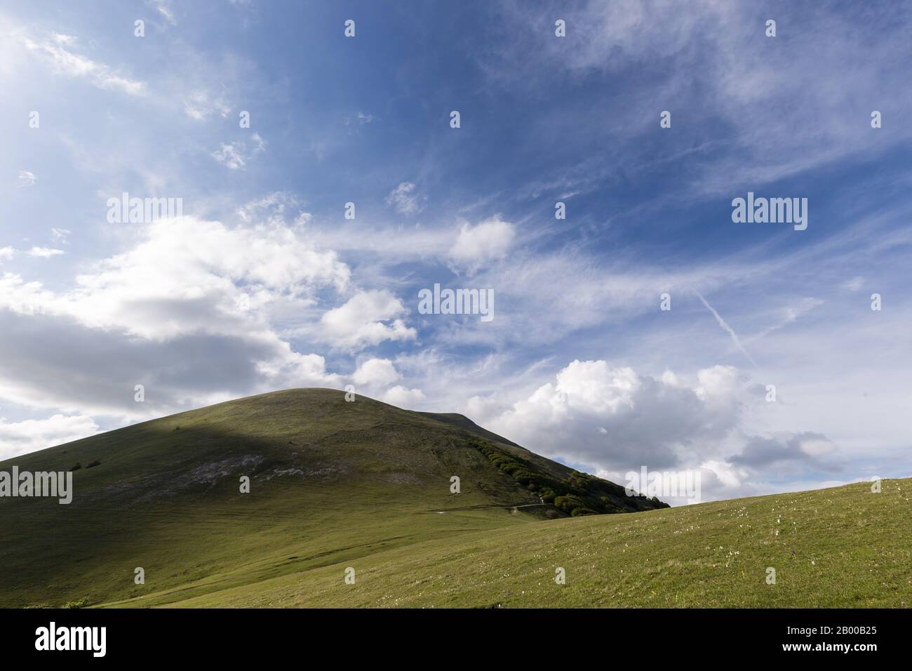 Mountains view in spring with green meadows and blue sky Stock Photo