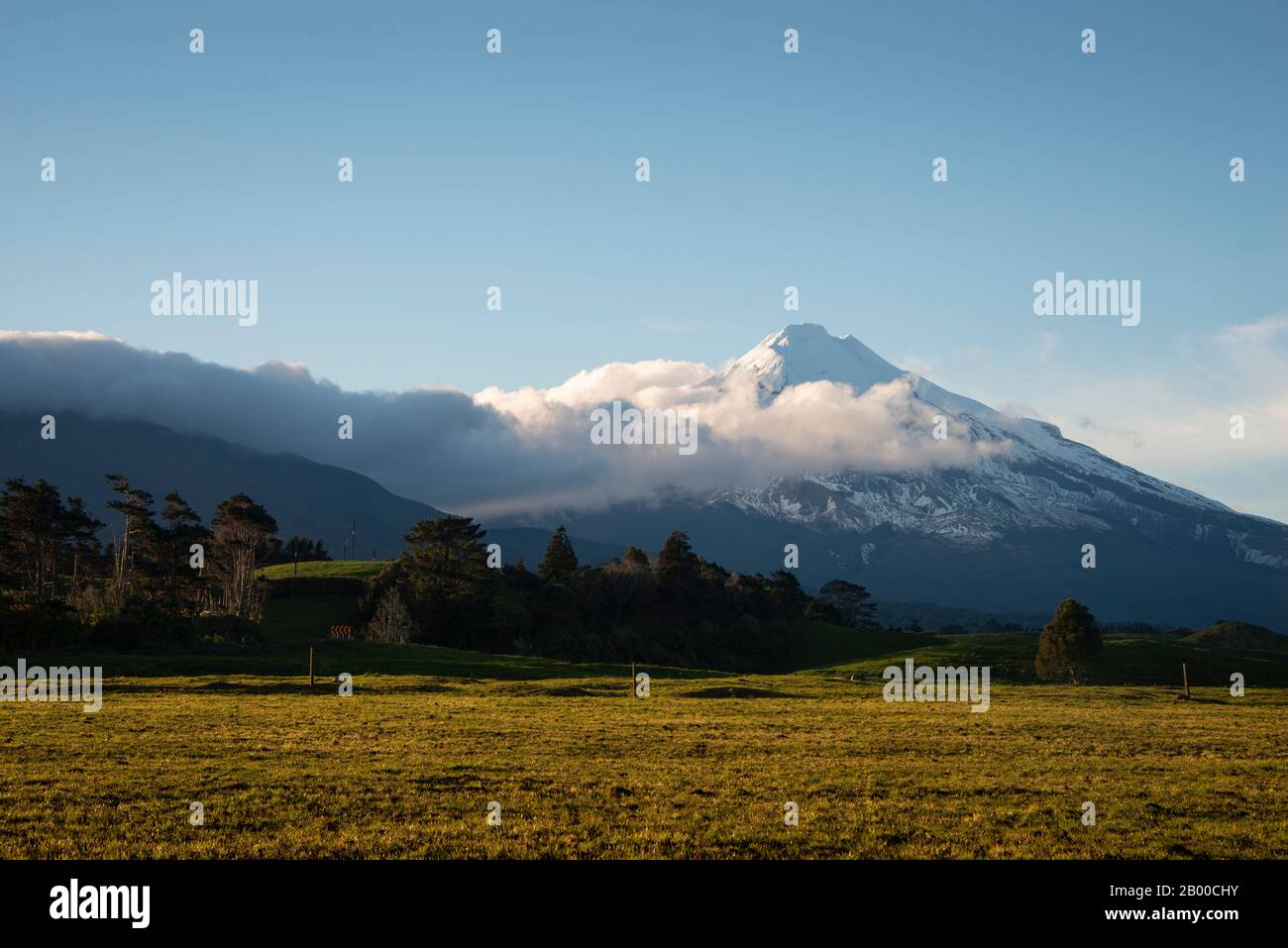 Mt Taranaki at Sunrise with clouds moving over the mountain Stock Photo