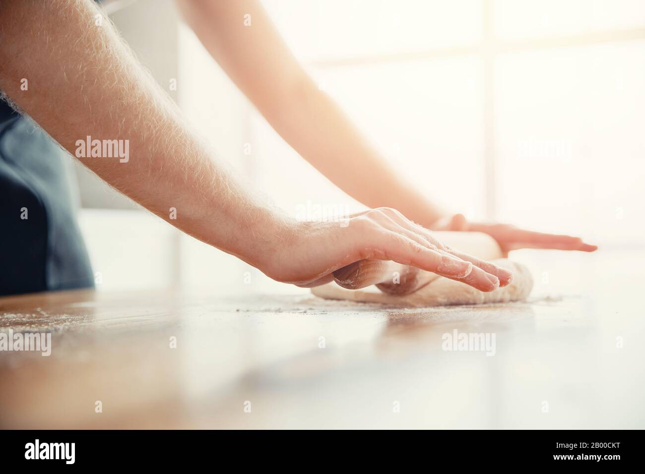 Chef hands rolling pizza dough on light kitchen background Stock Photo
