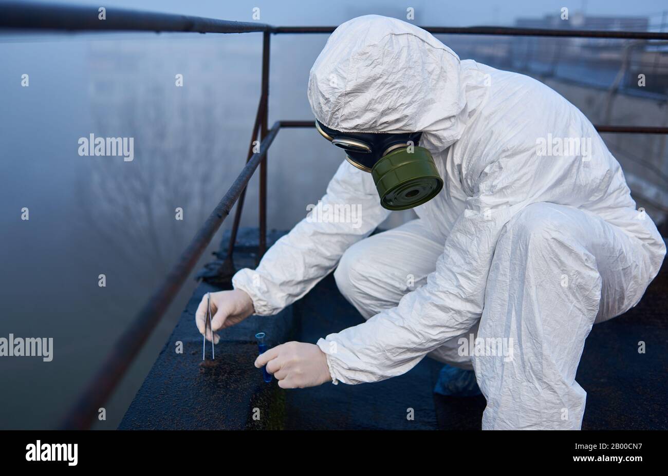 Scientist collecting samples for analysis in contaminated area, working