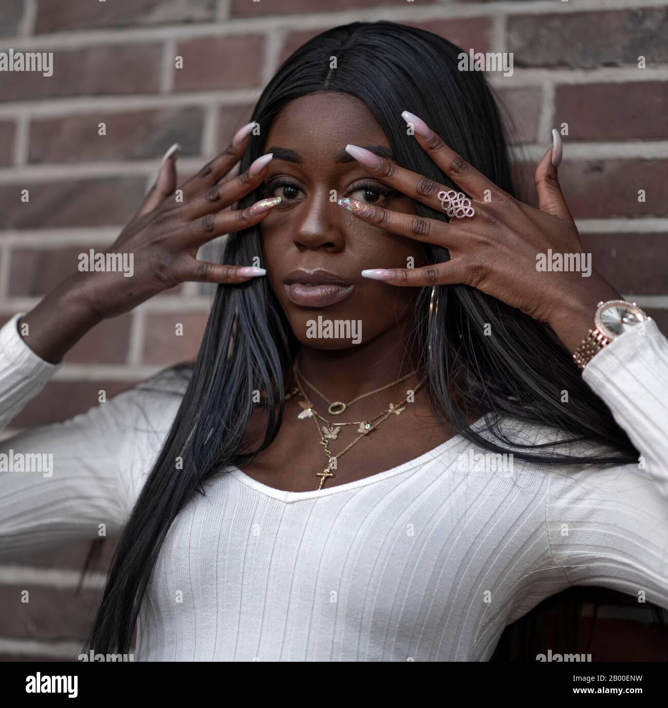 Dark skinned young woman, hands in front of her face, portrait, Duesseldorf, Germany Stock Photo