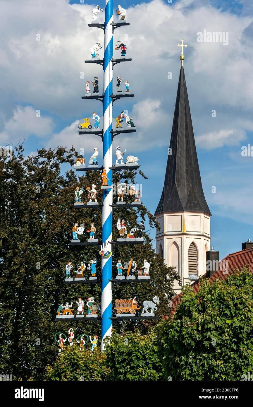 Maypole with guild sign, bell tower of the neo-gothic parish church of ...