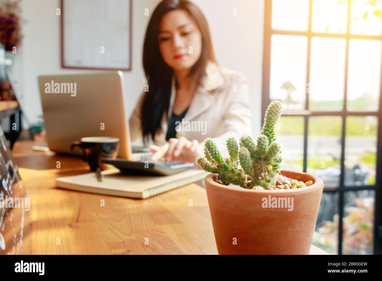 Asian business woman using calculator for accounting and analyzing investment in front of computer laptop at office workspace.  banking , savings , ac Stock Photo