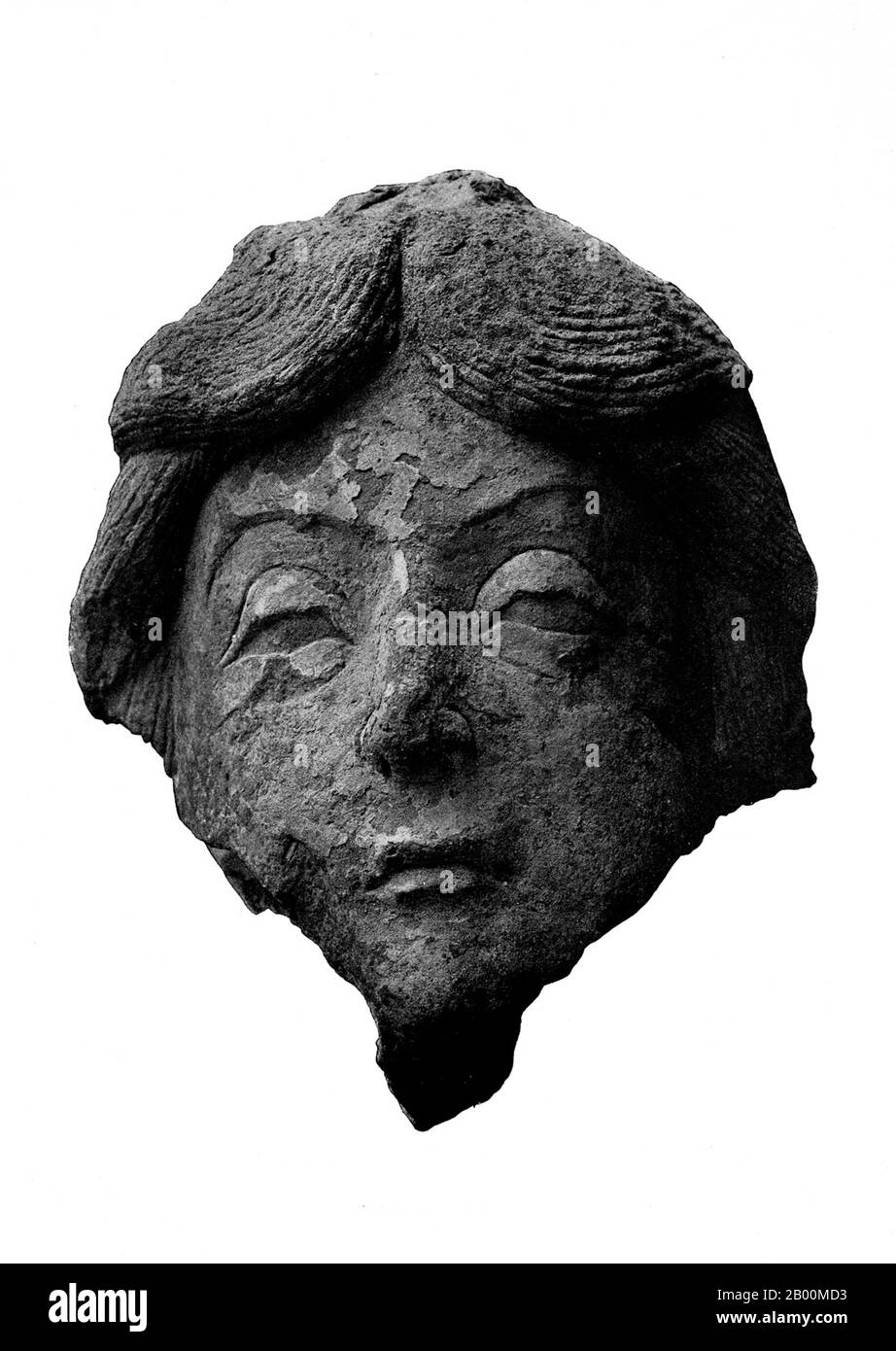 China: A stucco head from Miran, south Xinjiang.  In ancient times Miran was a busy trading center on the southern part of the Silk Road, after the route split into two (the northern route and the southern route), as caravans of merchants sought to escape travel across the harsh wasteland of the desert (called by the Chinese "The Sea of Death") and the Tarim Basin. They went by going around its north or south rim. It was also a thriving center of Buddhism with many monasteries and stupas. Marc Aurel Stein was the first archaeologist to systematically study the ruins at Miran in 1907. Stock Photo