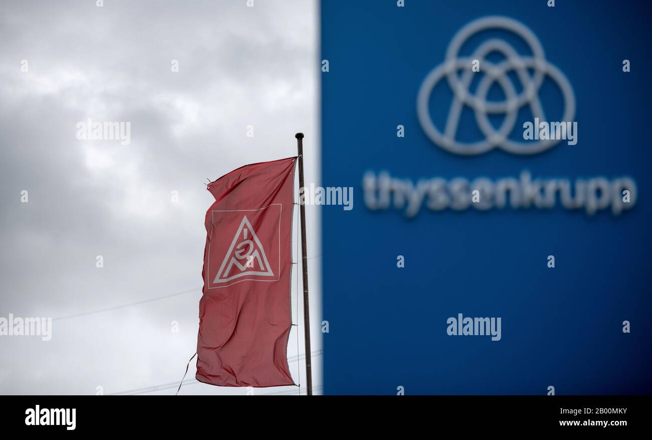 Duisburg, Germany. 18th Feb, 2020. The Thyssenkrupp logo is displayed on a sign in front of the HKM steelworks, behind which a flag of the IG-Metall union is flying. At the ailing steel group Thyssenkrupp, the heavy plate plant in Duisburg-Hüttenheim is threatened with closure. Credit: Fabian Strauch/dpa/Alamy Live News Stock Photo